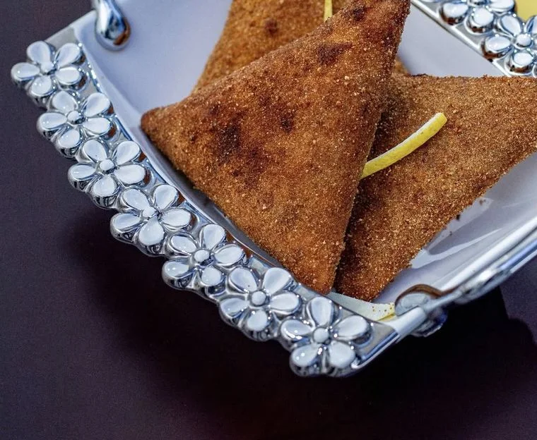 Giant crumbed samoosas on a silver tray
