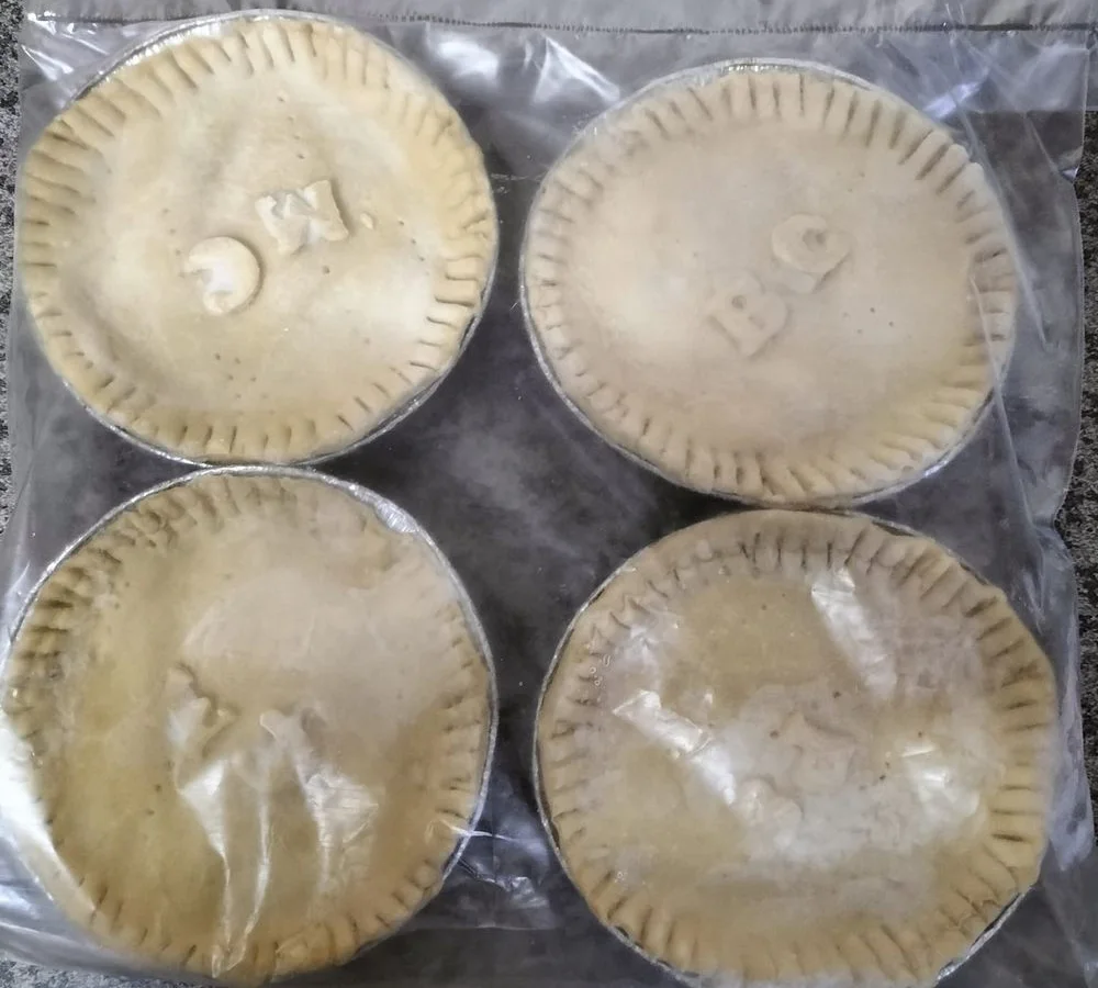 Four unbaked pies in a bag, with filling codes stamped on the crust
