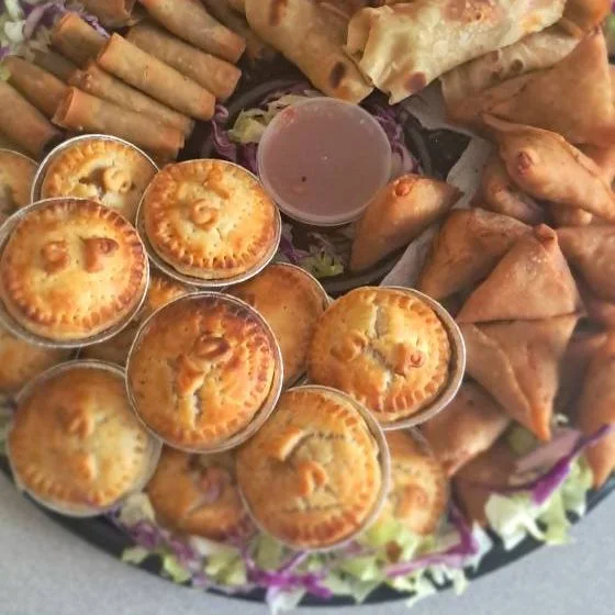 A platter of pies and samoosas on salad
